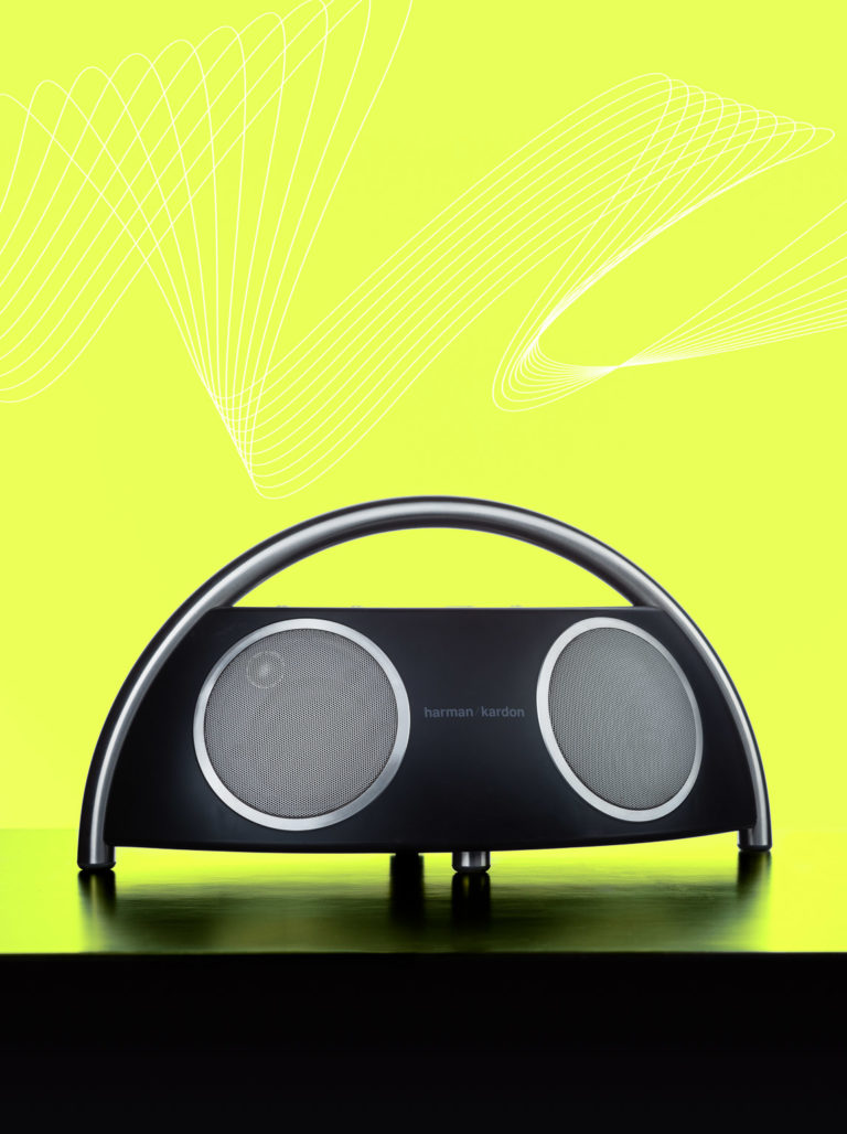 Product photography of Harmon Kardon speakers on bright green background