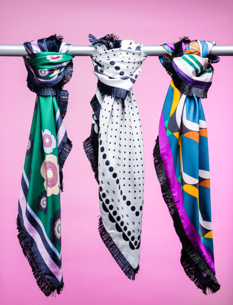 Product photography of three scarves on colored background